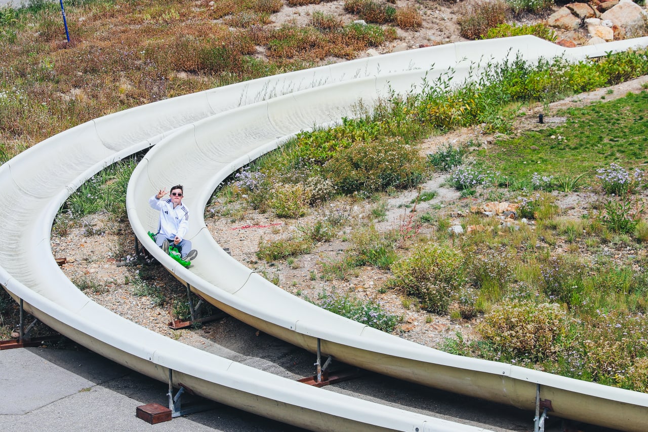 Chase Hitchcock slides down a slide while on the team outing in Salt Lake.