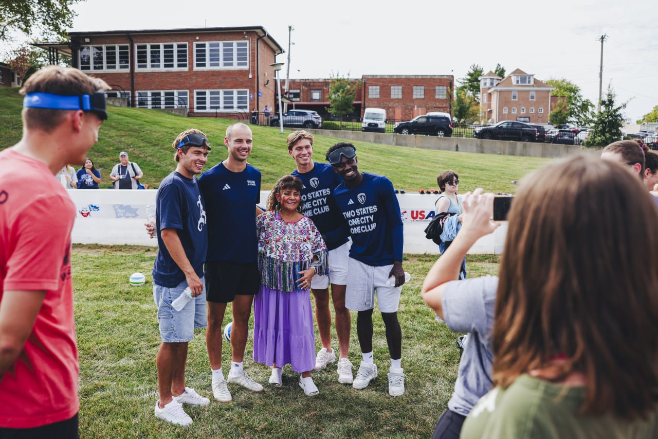 Sporting KC players pose with an event attendee for a photo.
