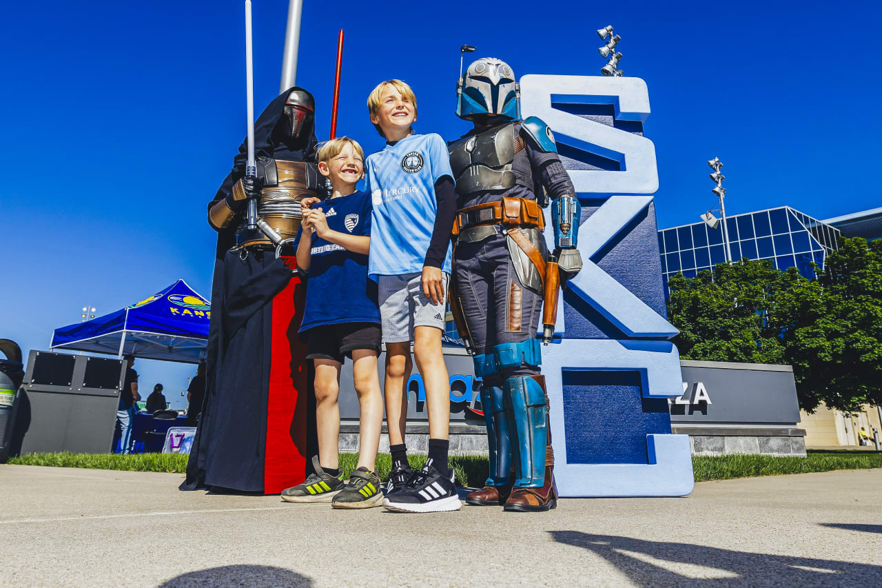 Two young fans pose with two Star Wars characters on Mazuma Plaza pregame on Sunday.