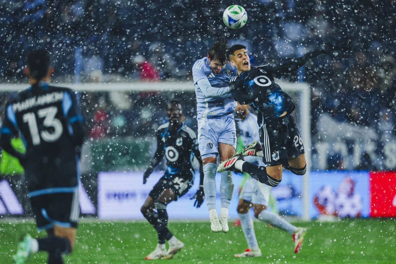 Sporting KC defender Jake Davis jumps to head a ball in the snow.