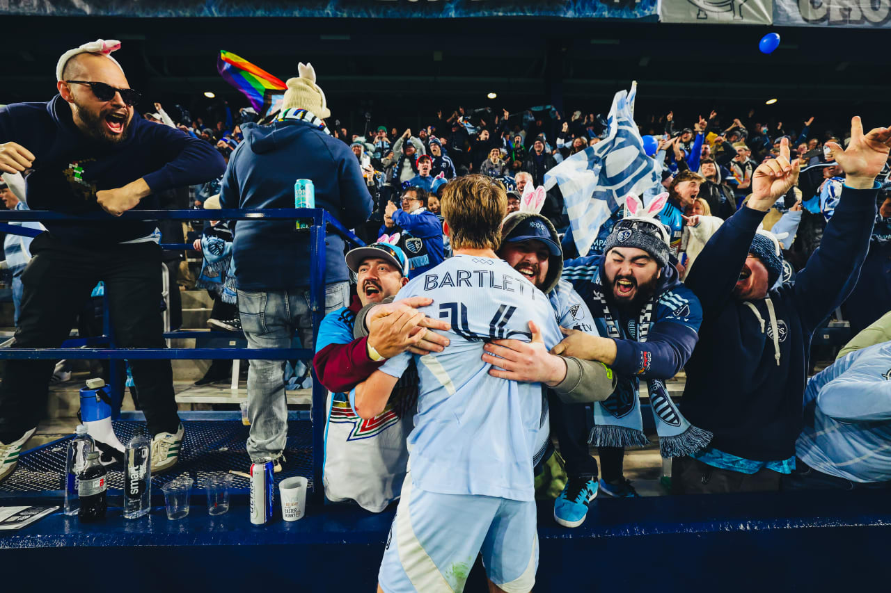 Two Sporting KC supporters hug Sporting KC midfielder Jacob Bartlett after the first goal was scored.