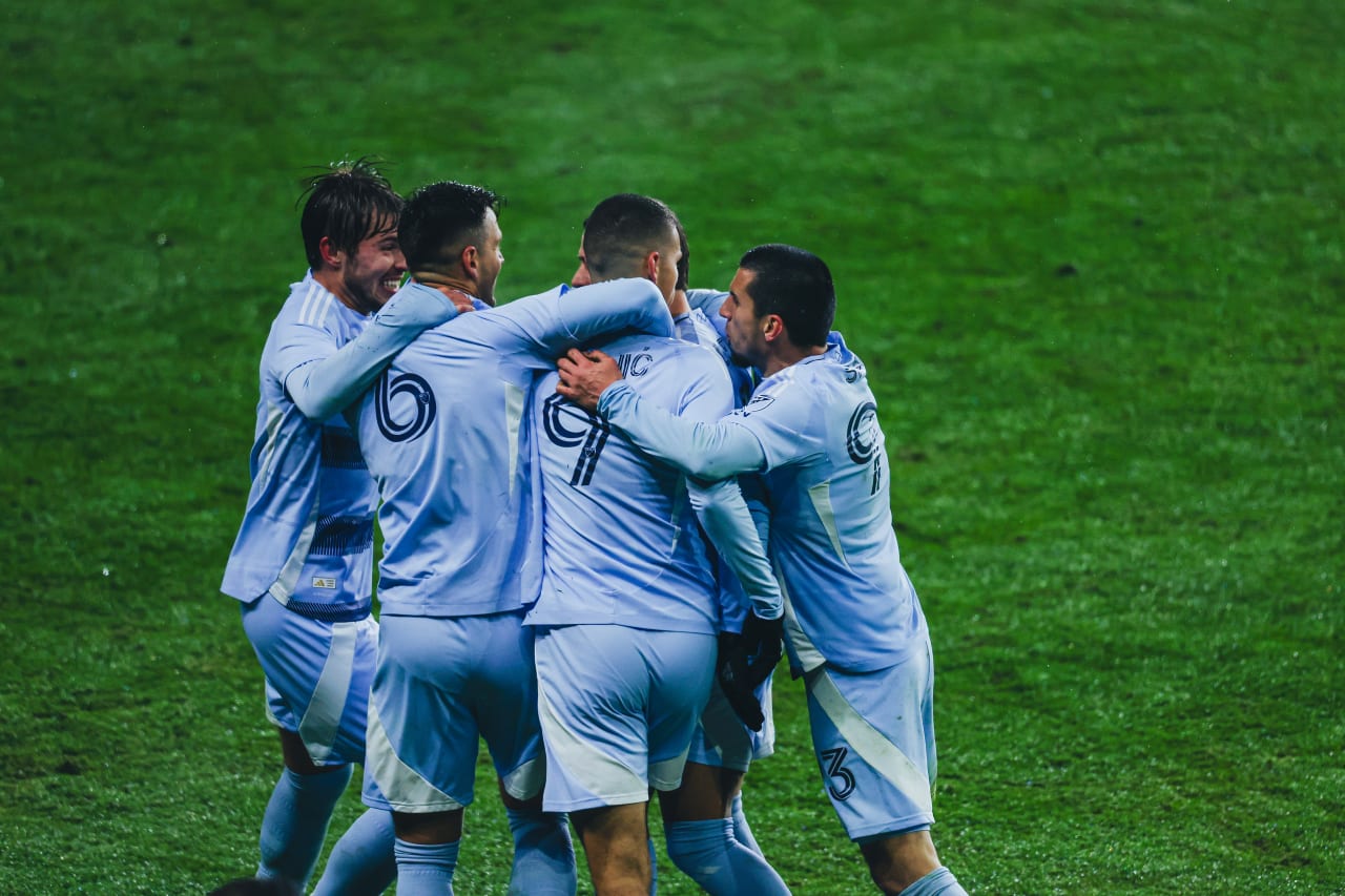 Sporting KC teammates crowd around Sporting KC forward Dejan Joveljic after he scores.