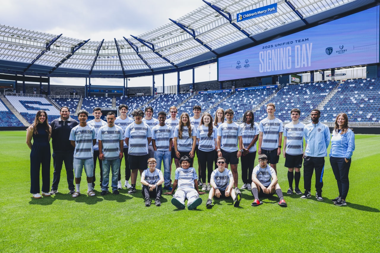 Unified team and coaches poses for a team photo at Children's Mercy Park on signing day.