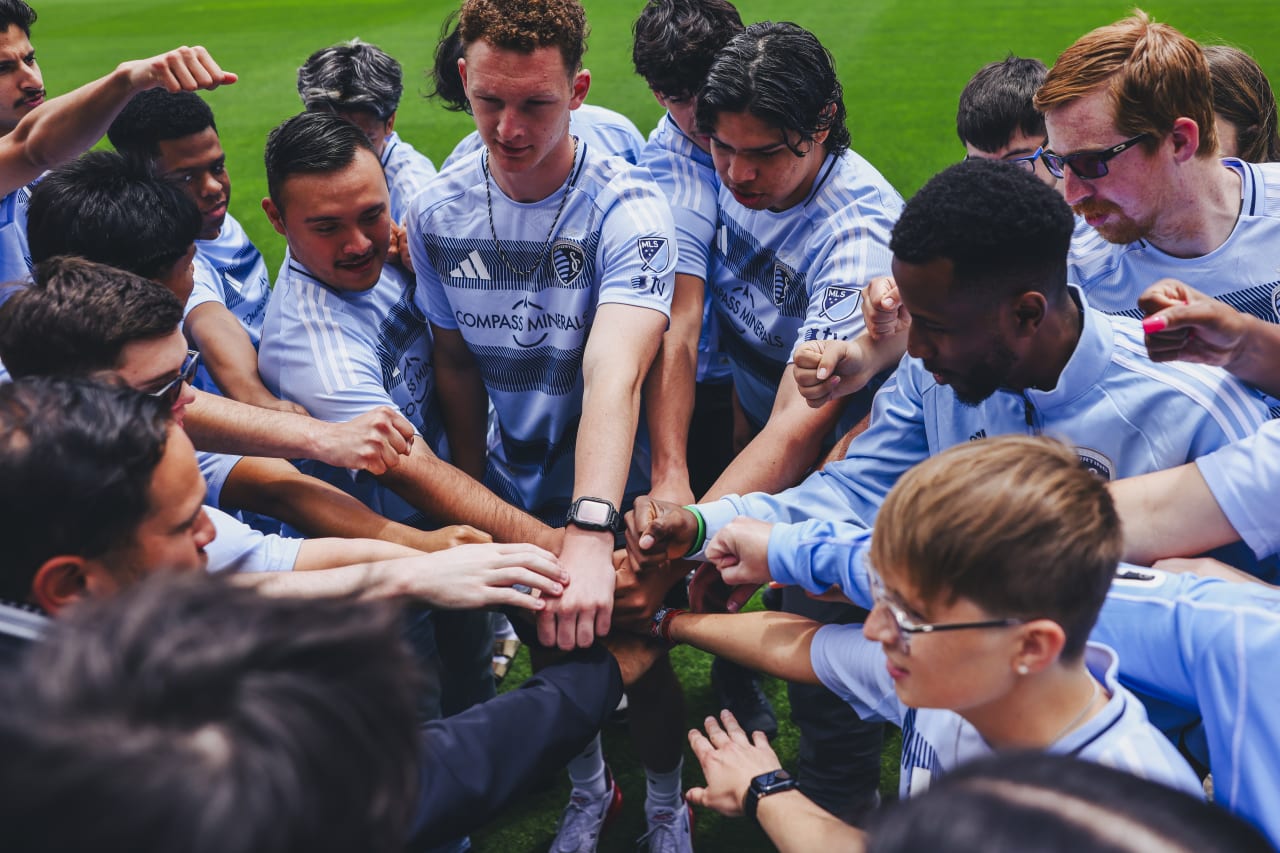 Unified players put their hands in during a huddle to