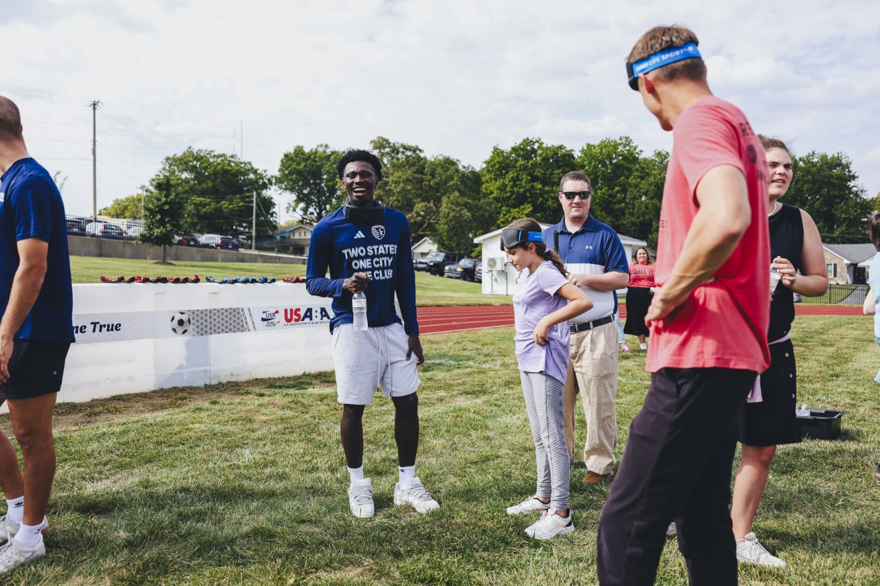 Sporting KC forward Stephen Afrifa talks with a KSSB blind soccer athlete.