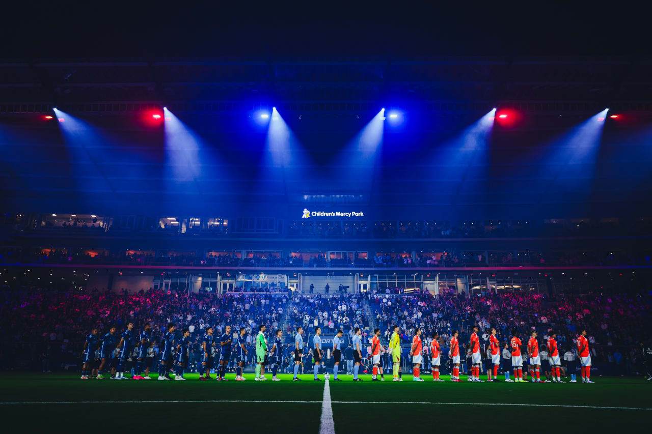 Players stand for the national anthem before the game vs Houston as the lights selectively illuminate the players.