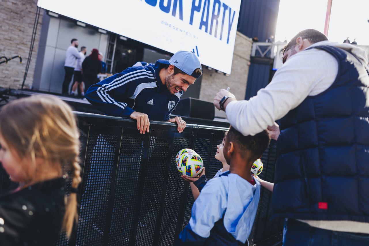 Sporting KC midfielder Jake Davis smiles with a few young fans as they ask for his signature.