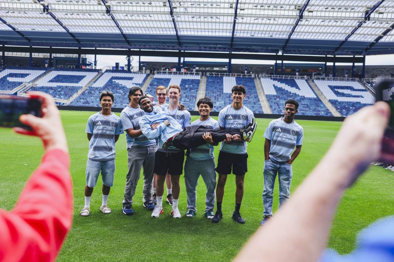Unified players hold up assistant coach for a photo