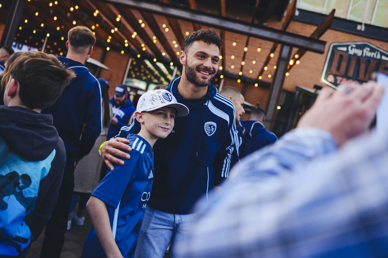Sporting KC goalkeeper John Pulskamp takes a photo with a young fan