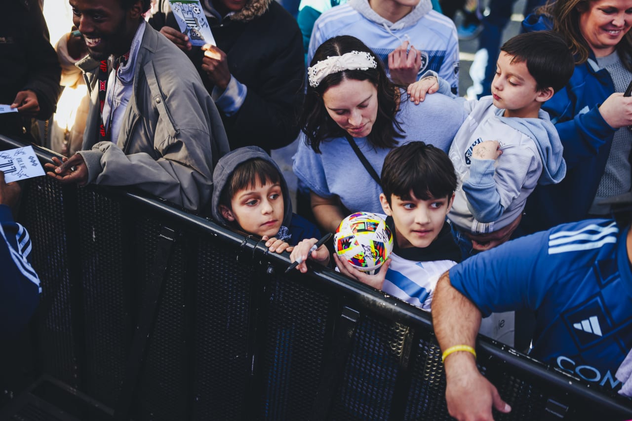 Two young Sporting KC fans wait in hope of signatures and photos with Sporting KC players