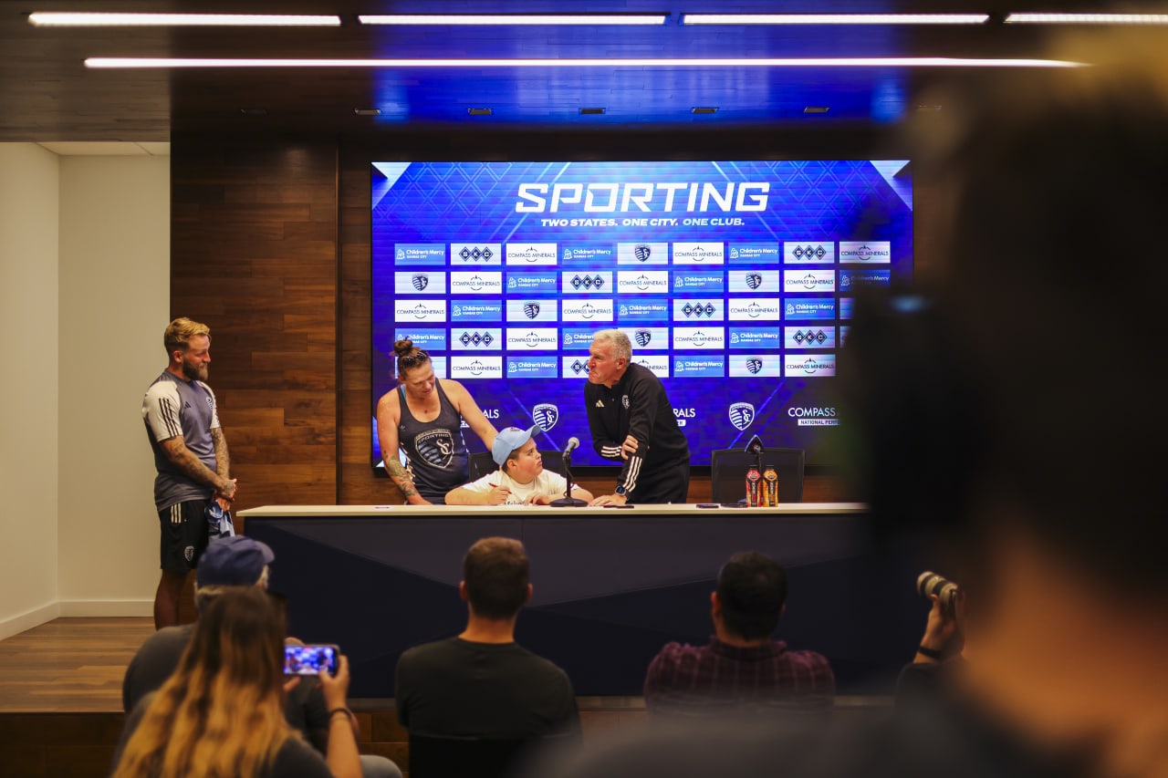 Next to Coach Peter Vermes, Miles Smith signs his contract with Sporting KC.
