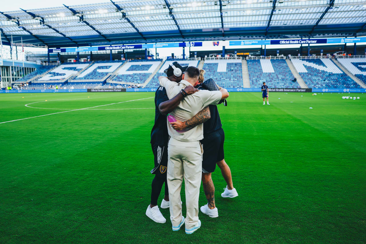 Sporting KC forward Erik Thommy hugs Real Salt Lake forwards Johnny Russell and William Agada in their first meeting since Russel and Agada joined Salt Lake.