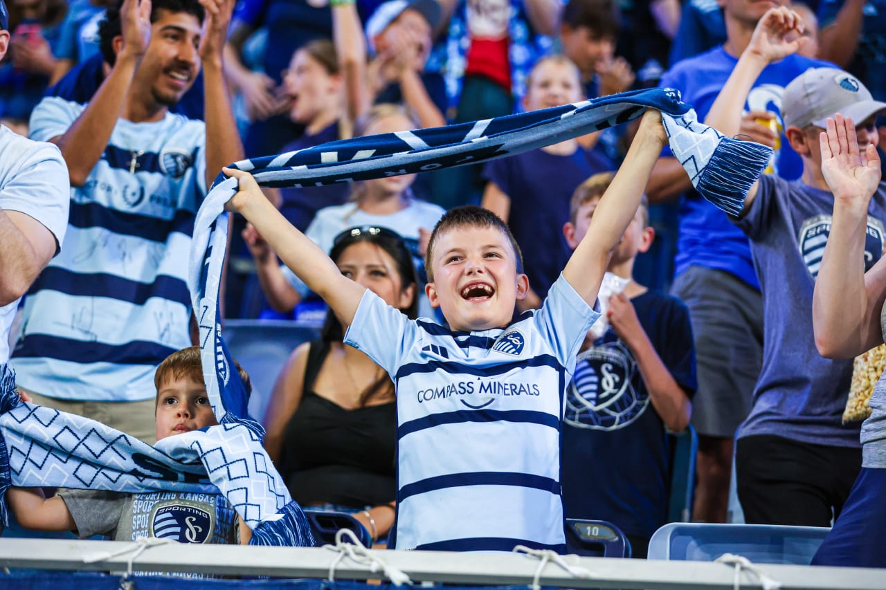 A young Sporting KC fans raises his scarf in the air and cheers on the team on June 29 during the SKC vs ATX match.
