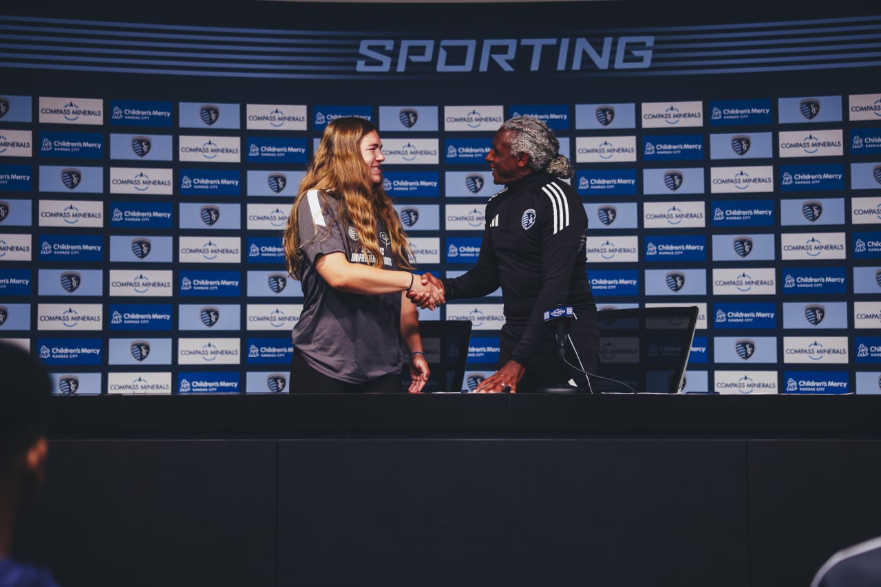 Unified player Helen Schmitt shakes Academy Director Declan Jogi's hand after signing his agreement