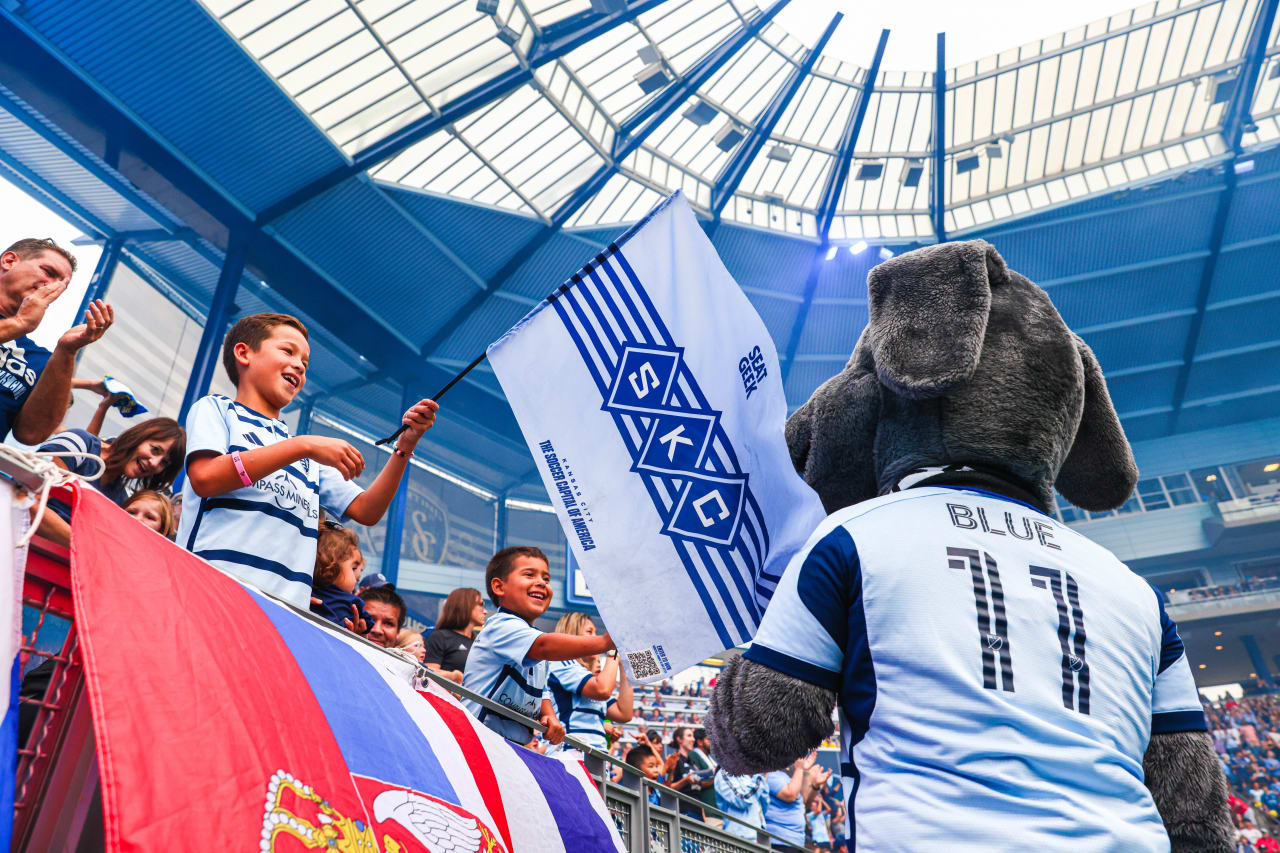 A small fan waves a large flag in front of Blue during the July 20 Rivalry match against St. Louis.