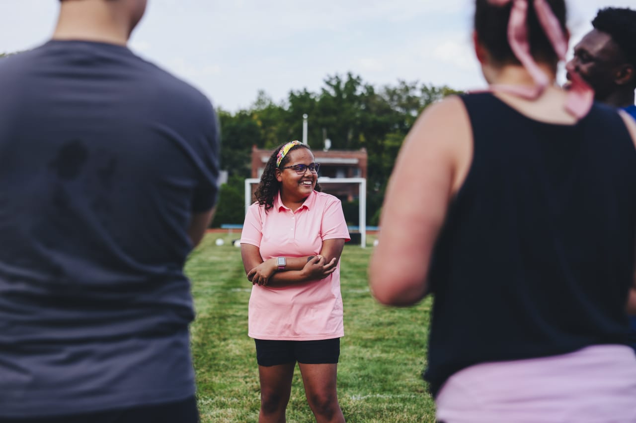 A KSSB blind soccer athlete laughs while talking with Sporting KC players.