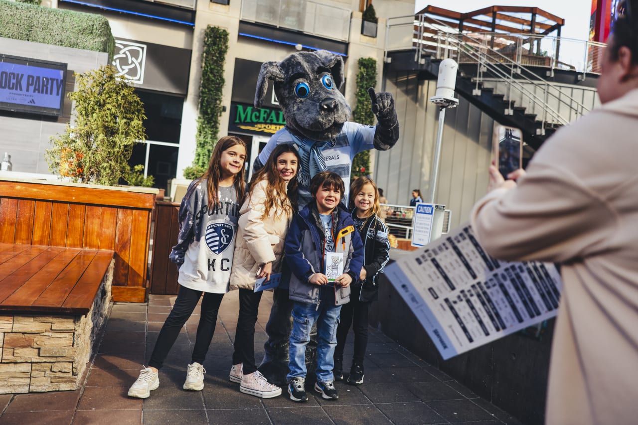 A group of young Sporting KC fans take a photo with Blue, Sporting KC's mascot.