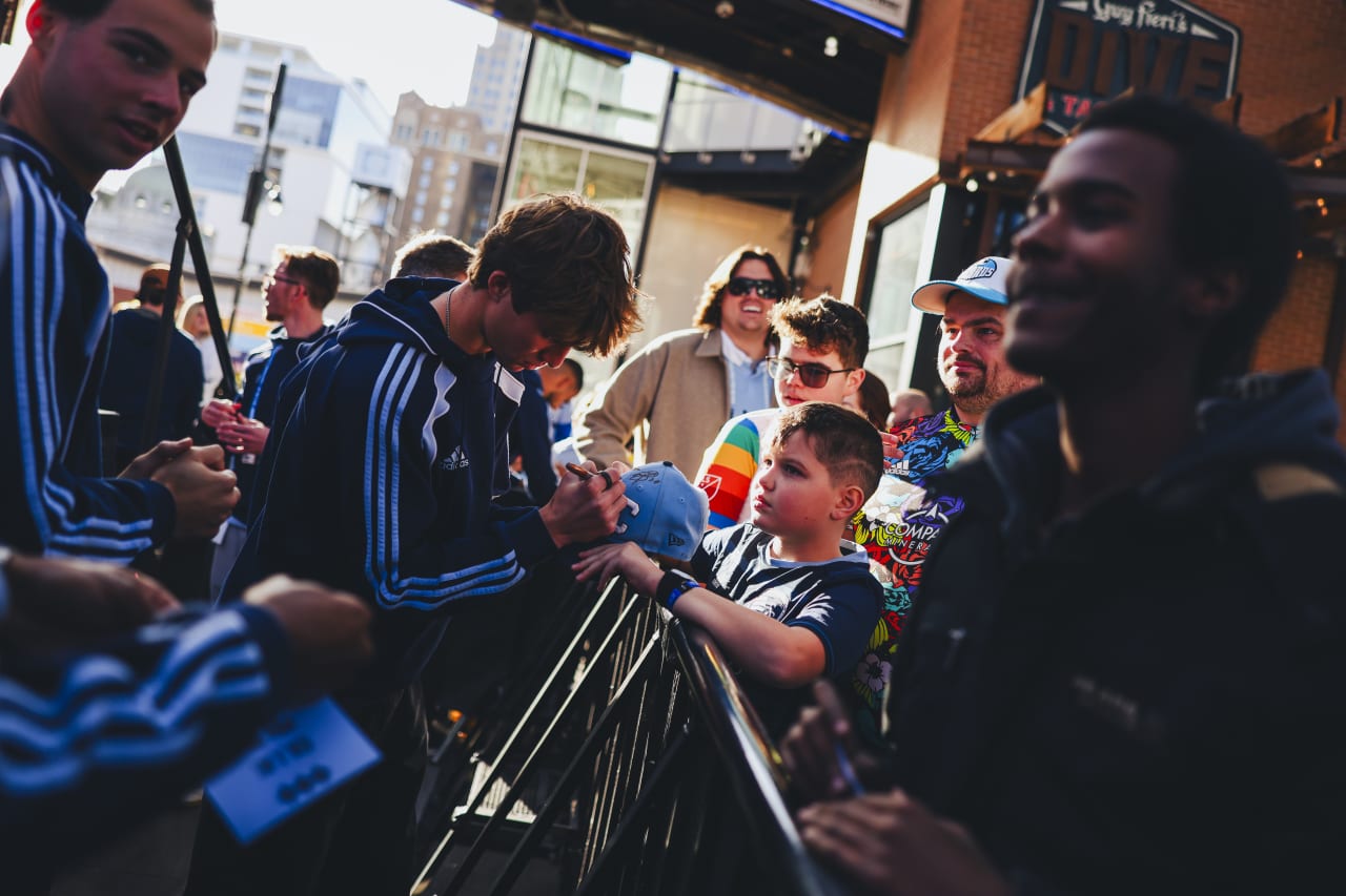 A young fan gets his hat signed by Jacob Bartlett